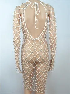 Detailansicht der Rückseite eines weißen gehäkelten Strandkleides mit Goldperlen.
