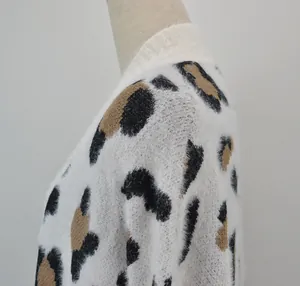 Dettaglio ravvicinato della texture pelosa e della stampa leopardata su maglione bianco a maglia