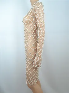 Nahaufnahme des weißen Häkel-Strandkleids mit goldenen Perlen in der Seitenansicht