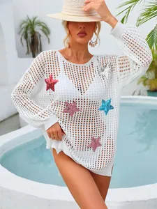 Dettaglio del copricostume bianco traforato con stelle di paillettes colorate applicate