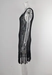 Dettaglio laterale di un copricostume nero all'uncinetto con eleganti frange.