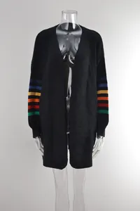 Détail du cardigan noir en maille avec des manches rayées aux couleurs de l'arc-en-ciel.
