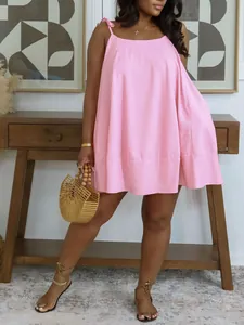Loose pink camisole babydoll dress featuring bow straps for a stylish summer vacation look