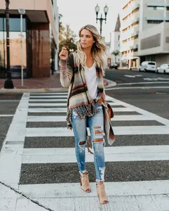Femme portant un cardigan en maille rayé à manches longues avec franges dans une rue