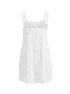 Back view of white A-line sundress featuring adjustable tie straps and button details.