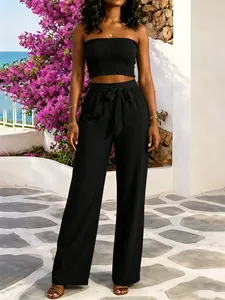 Elegante conjunto de dos piezas negro con top bandeau y pantalones anchos con cinturón.