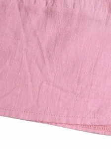 Macro detail of pink linen fabric texture and hemline stitching on a summer dress