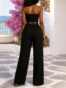 Detalle de la espalda del top bandeau negro y pantalones de pierna ancha en una modelo
