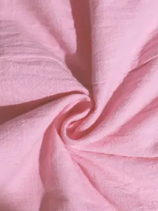 Macro view of soft pink crinkled cotton fabric texture detail for summer camisole dress