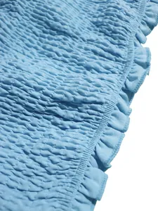 Detalle de primer plano de tela elástica fruncida azul claro con borde de volantes
