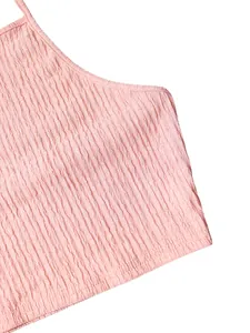Close-up macro detail of the pink pleated crinkle fabric on a summer halter crop top