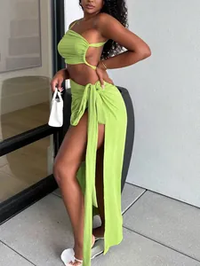Model wearing a vibrant lime green one-shoulder crop top and high-slit long skirt set
