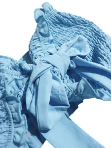 Detalle de cerca del top de tubo azul claro con tela elástica fruncida y lazo grande