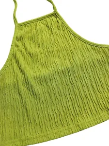 Detail shot showing the fine pleated texture of the lime green halter top fabric.
