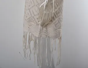 Primo piano di copricostume bianco all'uncinetto con frange e motivi a maglia traforata