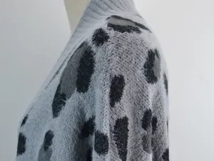 Primo piano della trama del cardigan grigio in maglia pelosa a stampa leopardata