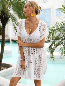 Elegantes weißes Strick-Strandkleid mit Lochmuster für einen stilvollen Sommerurlaub.