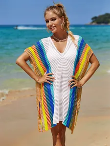 Vista dettagliata del copricostume all'uncinetto arcobaleno indossato da una modella in spiaggia.