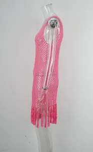 Vista laterale di un copricostume rosa all'uncinetto con nappe sul bordo per il mare
