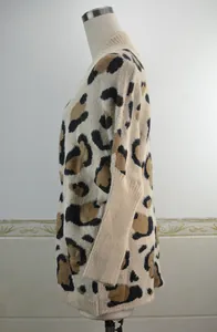 Dettaglio laterale di un cardigan beige oversize leopardato in maglia su manichino.