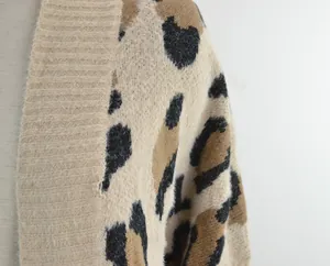 Vista macro della morbida trama del tessuto di questo elegante cardigan in maglia