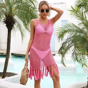 Copricostume rosa in maglia con frange indossato in una località balneare con piscina