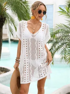 Detailansicht eines weißen Häkel-Strandkleids in einer sommerlichen Urlaubskulisse