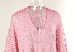 Detailed view of a pink crochet hollow-out beach cover-up with a V-neckline design