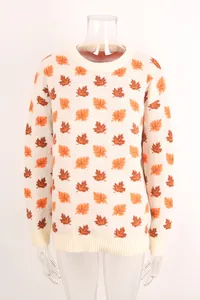 Close-up of knit sweater featuring orange and brown maple leaf patterns