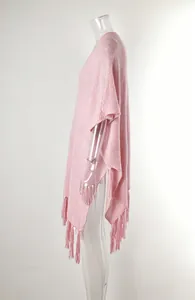 Detail of pink knitted beach cover-up featuring fringe tassels and hollow-out texture.