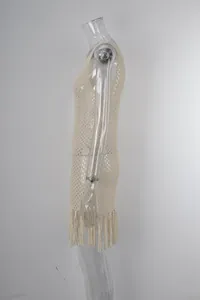 Vista laterale dettagliata di un copricostume in maglia beige con elegante orlo a frange.