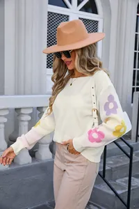 Side view of white oversized boat neck sweater with colorful floral patterns on sleeves