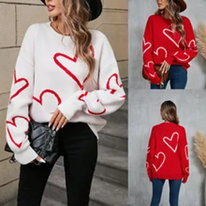 Detail view of women's cozy knitted heart print sweater pullovers in white and red colors
