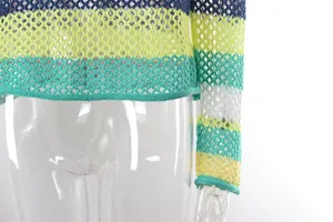 Close-up detail of rainbow striped hollow-out knitted beach cover-up hem and sleeve.