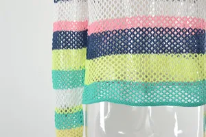 Macro detail of the vibrant rainbow striped hollow-out mesh knit beach cover-up.