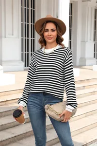 Casual zwart-wit gestreepte gebreide trui met lange mouwen gestyled met jeans en hoed