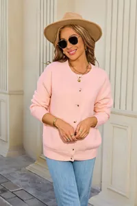 Chic soft pink knit cardigan with round neck and buttons shown on a model outdoors
