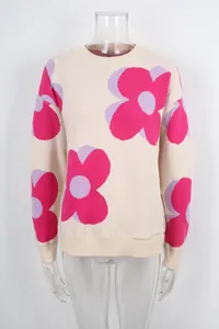 Close-up detail of a cream-colored knit sweater with large pink flower patterns