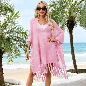 Chic pink crochet beach cover-up with stylish fringe tassels and relaxed oversized fit.