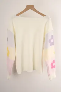 Close-up of knit texture and floral sleeve details on oversized boat neck sweater