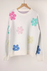 Detailed view of a white knit sweater featuring colorful flower patterns and round neck