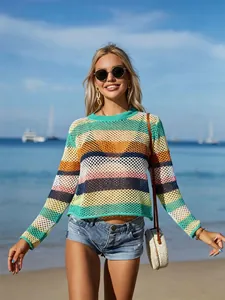 Outdoor view of a rainbow striped hollow-out knit beach cover-up on a model