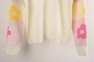 Detail view of off-white oversized knit sweater with colorful floral pattern sleeves