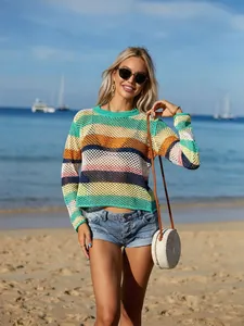 Rainbow striped crochet hollow beach cover-up worn by a model on a sunny beach