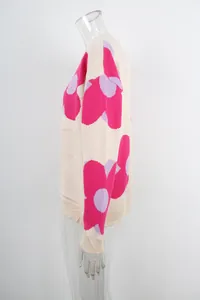 Side view detail of women's round neck knit sweater with large pink floral prints.
