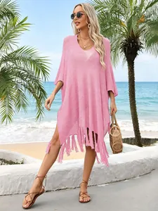 Detailed view of a pink knitted beach cover-up featuring loose fit and fringe tassels