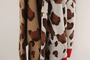 Close-up detail of leopard print knitted sweater with vibrant red ribbed cuffs