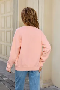 Back view of a cozy soft pink long-sleeve knit sweater paired with casual blue denim jeans