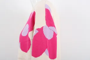 Macro detail of the vibrant pink and purple floral pattern on soft beige crewneck knit sweater