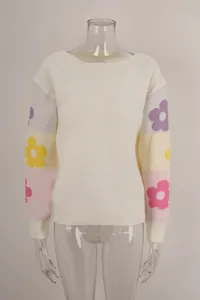 Detailed view of white boat neck knit sweater with colorful floral pattern sleeves